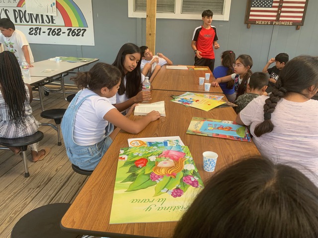 Youth reading books together at a community workshop table